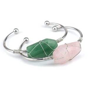 Detail of handmade wire wrapped raw green and pink crystals on silver bangle
