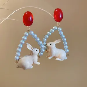 Boucles d'oreilles lapin rétro avec perles bleues et pendentif lapin blanc élégant