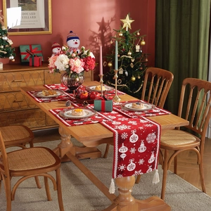 Red Christmas table runner and placemats set with white snowflakes and festive tassels