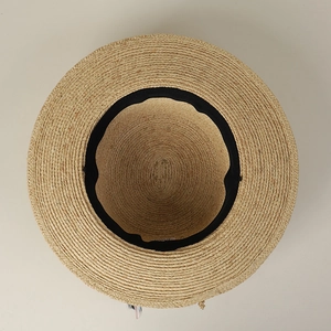 Detailed macro view of the interior sweatband and tight spiral weave of the raffia sun hat