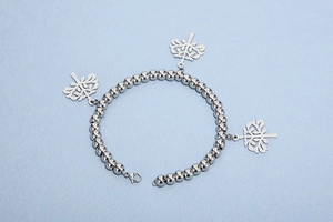 Détails du bracelet en perles argentées avec pendentifs arbre de vie et fermoir mousqueton