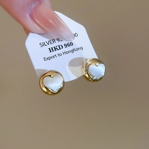 Detail of 925 silver gold heart stud earrings with white inlay on display card