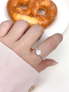 Close-up of minimalist silver ring with geometric square pattern on a hand