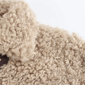 Detailed macro view of soft beige faux shearling fleece texture on autumn street jacket