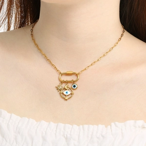 Gold stainless steel paperclip necklace with star, moon, and evil eye charms on a carabiner