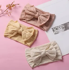 Detailed set of three knotted nylon cable knit baby headbands in soft pastel colors
