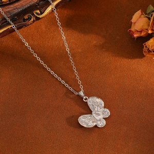 Halskette mit Schmetterlingsanhänger in Silber und Diamanten auf braunem Samt