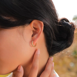Elegant gold U-shaped hoop earrings with micro-pave cubic zirconia on a model