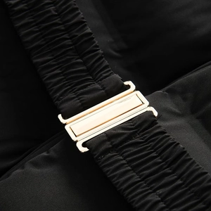 Detail of a gold metallic buckle on black elastic waist belt for women's padded jacket