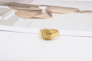 Macro shot of the golden Cupid angel relief on a vintage style titanium steel ring