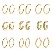 Macro view of various gold titanium steel hoop earrings in different textures and sizes