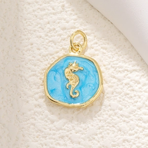 Detailed close-up of golden seahorse pendant with sparkling blue enamel and shiny finish