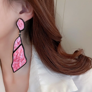 Close-up of geometric pink marble acrylic earrings with irregular black metal framing