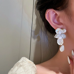 Elegant white shell flower petal earrings with tassels and crystals shown on a model