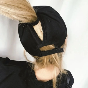 Detail of black ponytail baseball cap showing the high opening and adjustable strap