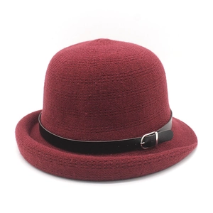 Detail of wine red knitted cloche hat with black leather belt and silver buckle accent