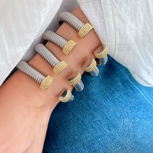 Chic two-tone silver and gold flexible spring cuff bracelets on a female wrist