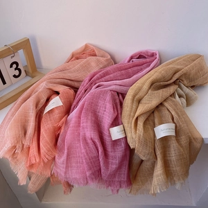 Elegant gradient linen scarves in orange, pink, and beige with fringed edges