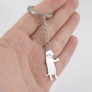 Polished stainless steel cartoon cat keychain with thumbs up pendant on a flat palm