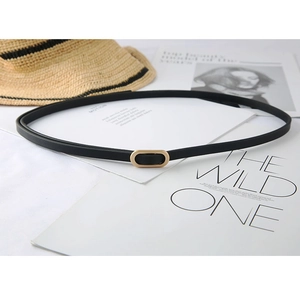 Minimalist black slim belt for women with golden oval buckle on aesthetic background
