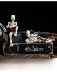 Macro shot of two resin skeleton figurines reading books for Gothic home desk decor