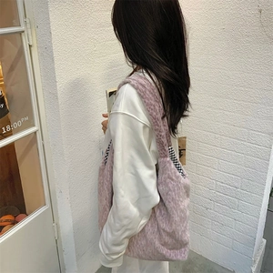 Detail showing soft pink faux fur texture and black and white checkered lining of tote bag