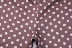 Vue détaillée des coutures et de la texture du legging marron foncé à pois blancs