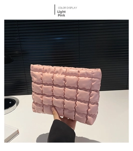 Détail de la texture matelassée rose clair et du matériau rembourré doux de la pochette