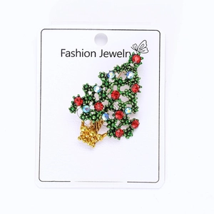 Detailed view of hollow Christmas tree brooch with green enamel and vibrant rhinestones