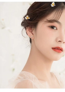 Close-up of s925 silver leaf stud earrings with zircon details on a female model