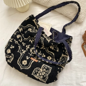 Close-up of vintage plush tote bag with black and white floral patterns and leather logo