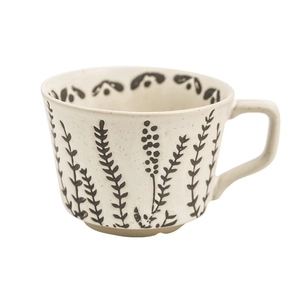 Minimalist hand-painted ceramic mug with black botanical patterns on a creamy base