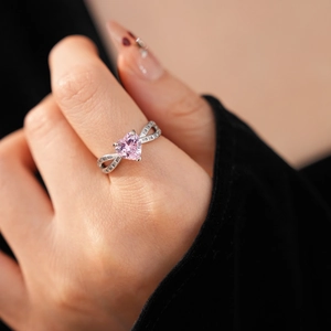 Detail of pink heart-shaped zircon ring with silver-white band and micro-pave crystals