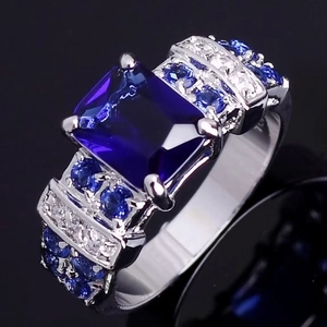 Macro detail of royal cocktail ring with large blue gemstone and pavé settings
