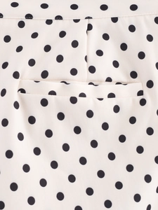 Détail de la couture de poche sur tissu beige avec imprimé à pois noirs