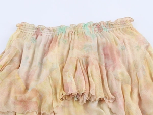 Close-up of elastic waistband and layered ruffle hem on floral chiffon midi skirt