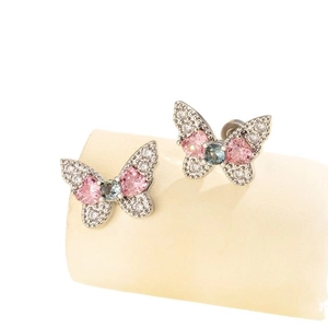 Sparkling butterfly ear studs with pink and blue zircons on a beige display stand