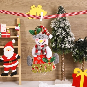 Detail of Christmas snowman ornament with SNOW lettering and plaid hat hanging on ribbon