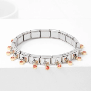 Silver modular link bracelet with gold charms and orange-red gemstones on white decor
