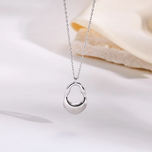 Macro detail of silver irregular hollow waterdrop pendant with high polished finish