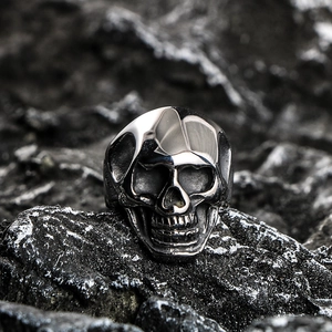 Silver skull ring for men in punk style on dark rock background, made of stainless steel