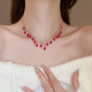 Detail of rose red teardrop crystal fringe necklace with gold chain on a model