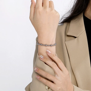 Détail d'un bracelet à billes argentées avec des perles polies alternées sur le poignet