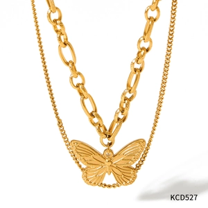 Détail d'un collier double épaisseur doré avec chaîne à maillons et pendentif papillon