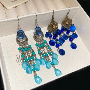 Detail view of Bohemian style shell earrings with beads and silver tassels in jewelry box