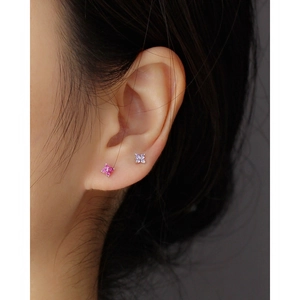 Macro shot of 925 sterling silver four-leaf flower studs in pink and lavender colors