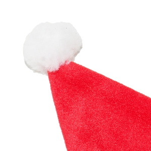 Close-up of a red plush Christmas hat featuring a white pompom and soft fabric texture