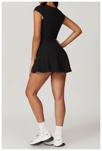 Back view of black yoga set featuring tight short sleeve top and pleated tennis skirt