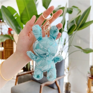 Blue plush bunny keychain with gold geometric patterns and metallic clasp