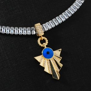 Macro shot of gold-plated evil eye necklace with blue stone and white cubic zirconia